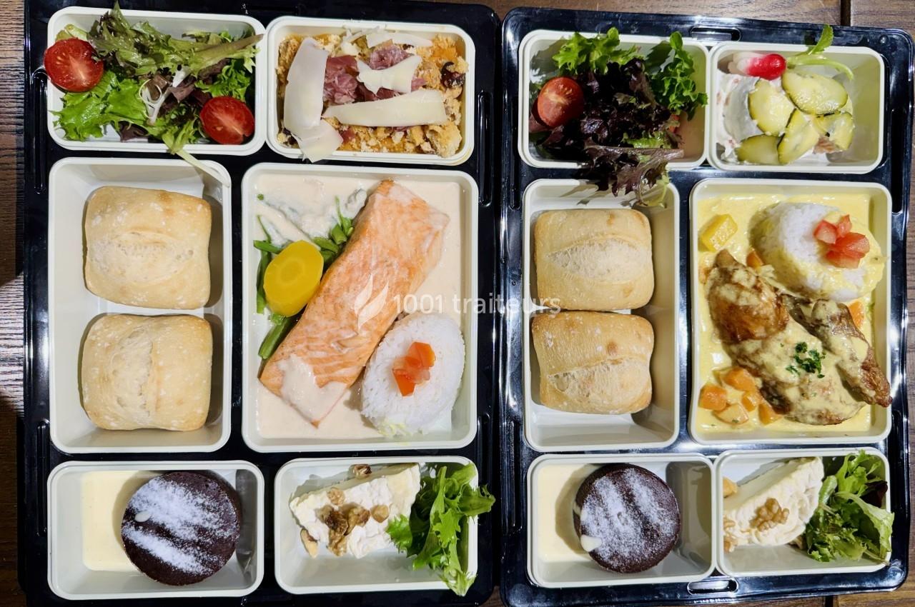 Plateaux-repas composés de saumon, poulet, légumes, riz, salades, pains, desserts et fromage.