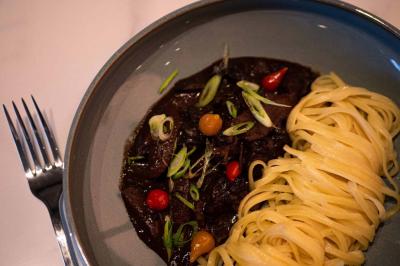 Deux machines à sous lumineuses avec écrans colorés, une personne assise devant l'une d'elles dans un casino.