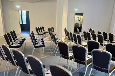 Deux machines à sous lumineuses avec écrans colorés, une personne assise devant l'une d'elles dans un casino.