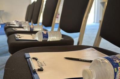 Deux machines à sous lumineuses avec écrans colorés, une personne assise devant l'une d'elles dans un casino.