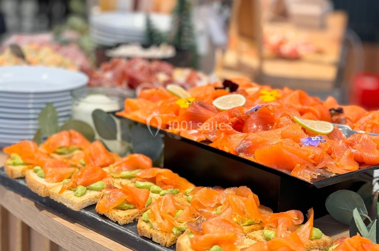 Plateau de toasts garnis de saumon fumé et d'avocat, accompagné d'un plat de saumon tranché avec décorations.