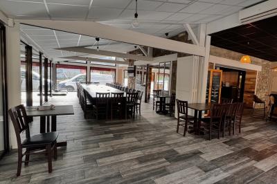 Un kayakiste pagaye sur une rivière calme entourée de végétation et de falaises verdoyantes.