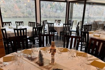 Miniature Location salle Caloire (Loire) - Domaine du Moulin #2 Salle de réunion avec tables en bois disposées en U, chaises, carafes d'eau et verres, éclairée par des lumières extérieures.