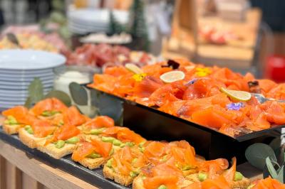 Miniature Location salle Caloire (Loire) - Domaine du Moulin #9 Salle de réunion avec tables en bois disposées en U, chaises, carafes d'eau et verres, éclairée par des lumières extérieures.