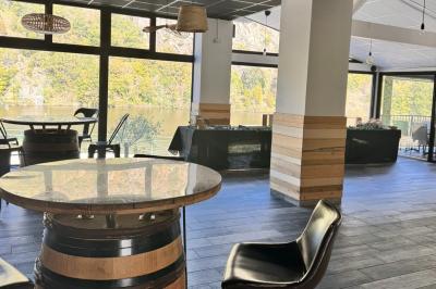 Miniature Location salle Caloire (Loire) - Domaine du Moulin #8 Salle de réunion avec tables en bois disposées en U, chaises, carafes d'eau et verres, éclairée par des lumières extérieures.