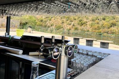 Miniature Location salle Caloire (Loire) - Domaine du Moulin #7 Salle de réunion avec tables en bois disposées en U, chaises, carafes d'eau et verres, éclairée par des lumières extérieures.