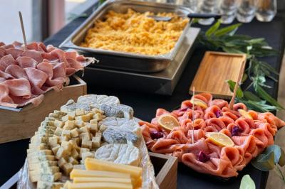 Miniature Location salle Caloire (Loire) - Domaine du Moulin #11 Salle de réunion avec tables en bois disposées en U, chaises, carafes d'eau et verres, éclairée par des lumières extérieures.