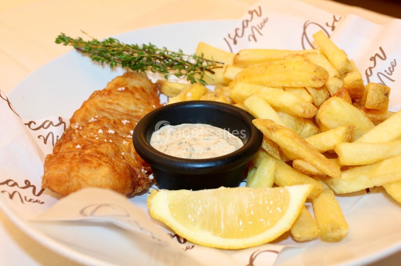 Assiette de fish and chips avec frites, filet de poisson pané, sauce tartare, citron et brin de thym en garniture.