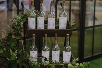 Bougies allumées sur une table décorée avec des verres, assiettes empilées et serviettes pliées.
