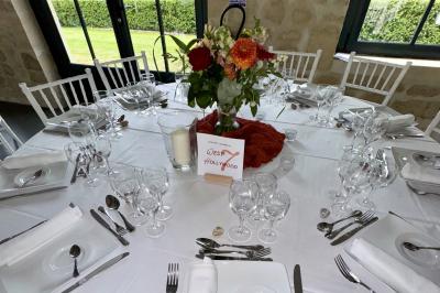 Bougies allumées sur une table décorée avec des verres, assiettes empilées et serviettes pliées.