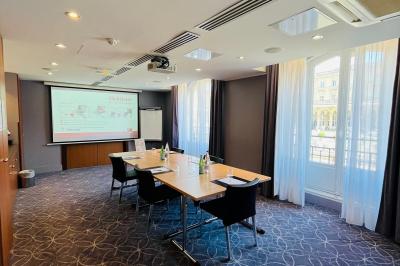 Salle de bain moderne avec lavabo suspendu, douche vitrée, toilettes et murs ornés de motifs en relief.