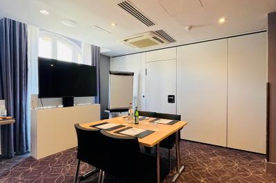 Salle de bain moderne avec lavabo suspendu, douche vitrée, toilettes et murs ornés de motifs en relief.