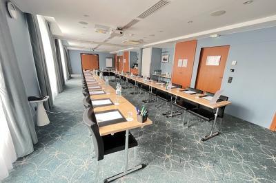 Salle de bain moderne avec lavabo suspendu, douche vitrée, toilettes et murs ornés de motifs en relief.