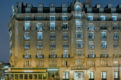 Salle de bain moderne avec lavabo suspendu, douche vitrée, toilettes et murs ornés de motifs en relief.