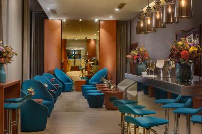Salle de bain moderne avec lavabo suspendu, douche vitrée, toilettes et murs ornés de motifs en relief.