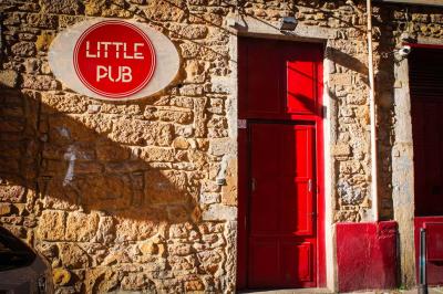 Portant en bois dans une armoire ouverte, éclairée par une lumière rose, avec plusieurs cintres suspendus.