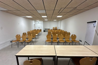 Espace de fabrication équipé de machines et rangements, avec un décor minimaliste et des murs blancs.