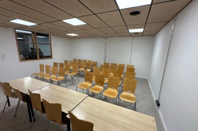 Espace de fabrication équipé de machines et rangements, avec un décor minimaliste et des murs blancs.