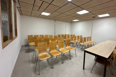 Espace de fabrication équipé de machines et rangements, avec un décor minimaliste et des murs blancs.