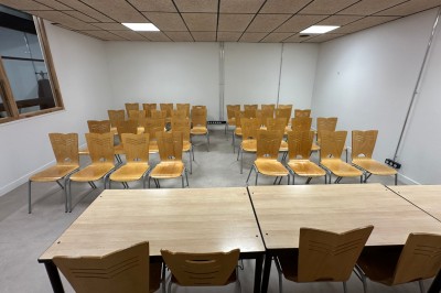 Espace de fabrication équipé de machines et rangements, avec un décor minimaliste et des murs blancs.