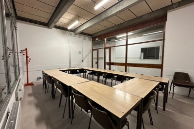 Espace de fabrication équipé de machines et rangements, avec un décor minimaliste et des murs blancs.