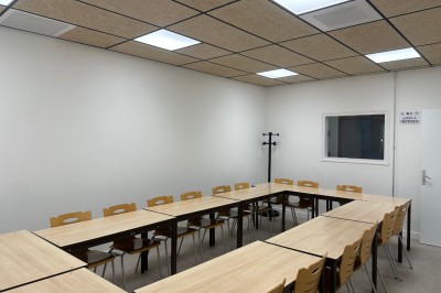 Espace de fabrication équipé de machines et rangements, avec un décor minimaliste et des murs blancs.