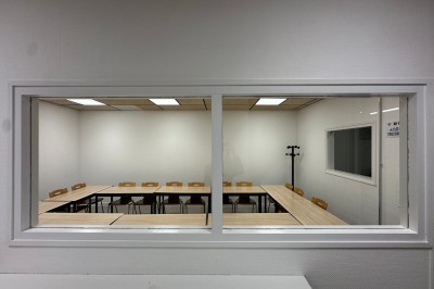 Espace de fabrication équipé de machines et rangements, avec un décor minimaliste et des murs blancs.