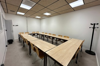 Espace de fabrication équipé de machines et rangements, avec un décor minimaliste et des murs blancs.