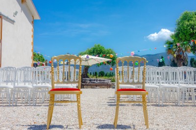 Un groupe de personnes, dont un couple en tenue de mariage, pose en extérieur devant un paysage montagneux.