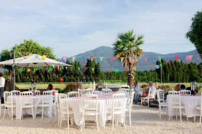 Un groupe de personnes, dont un couple en tenue de mariage, pose en extérieur devant un paysage montagneux.