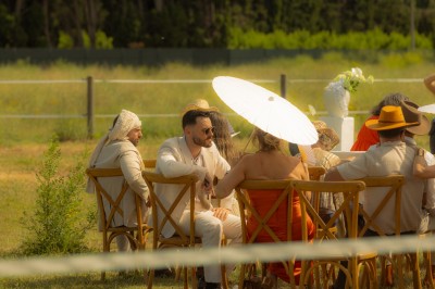 Un groupe de personnes, dont un couple en tenue de mariage, pose en extérieur devant un paysage montagneux.