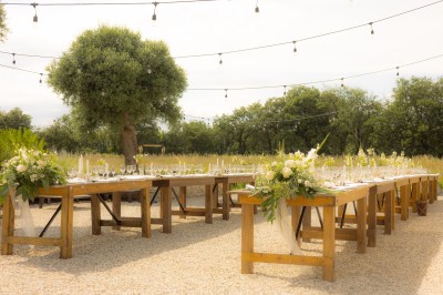 Un groupe de personnes, dont un couple en tenue de mariage, pose en extérieur devant un paysage montagneux.