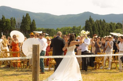 Un groupe de personnes, dont un couple en tenue de mariage, pose en extérieur devant un paysage montagneux.