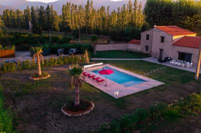 Miniature Gîte sur place Vue aérienne d'une maison en pierre avec piscine, jardin, terrasse et espaces verts environnants.
