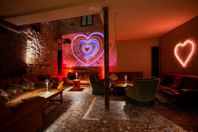 Miniature Location salle Nanterre (Hauts-de-Seine) - Les Enfants Terribles #10 Façade d'un café-restaurant avec terrasse vide, éclairée par des lumières colorées en soirée pluvieuse.