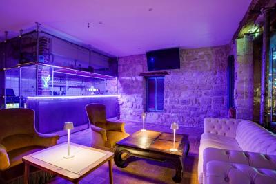 Miniature Location salle Nanterre (Hauts-de-Seine) - Les Enfants Terribles #2 Façade d'un café-restaurant avec terrasse vide, éclairée par des lumières colorées en soirée pluvieuse.