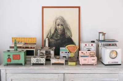 Collection de jouets anciens représentant des cuisinières miniatures et une balance rétro sur une étagère.