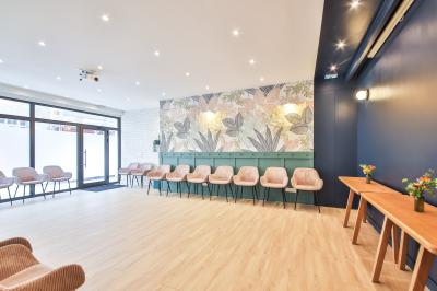 Salle de bain moderne avec murs pêche, lavabo sur meuble en bois, miroir rond et toilettes.