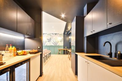 Salle de bain moderne avec murs pêche, lavabo sur meuble en bois, miroir rond et toilettes.