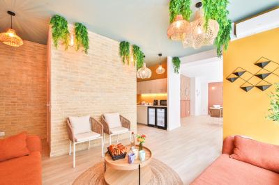 Salle de bain moderne avec murs pêche, lavabo sur meuble en bois, miroir rond et toilettes.