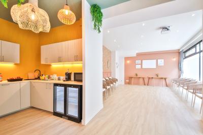 Salle de bain moderne avec murs pêche, lavabo sur meuble en bois, miroir rond et toilettes.