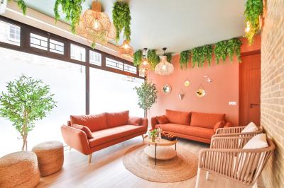 Salle de bain moderne avec murs pêche, lavabo sur meuble en bois, miroir rond et toilettes.