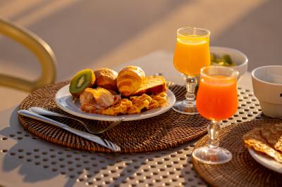 Miniature Location salle Le Lavandou (Var) - Résidences Kaliopé #17 Petit-déjeuner composé de viennoiseries, fruits, œufs, jus d'orange et café, servi sur une table ensoleillée.