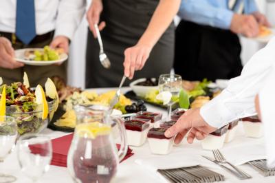 Personnes pratiquant le yoga sur une plage au coucher du soleil, en position debout avec les bras levés.