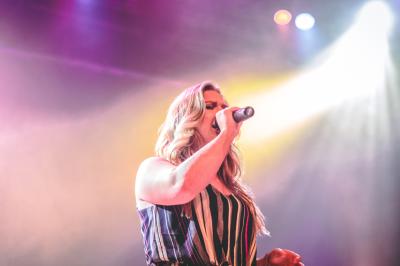 Un homme déguisé en Père Noël lit une lettre avec deux enfants souriants dans un décor chaleureux.