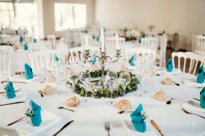 Salle spacieuse avec carrelage au sol, grandes baies vitrées, poutres apparentes et lustres suspendus.