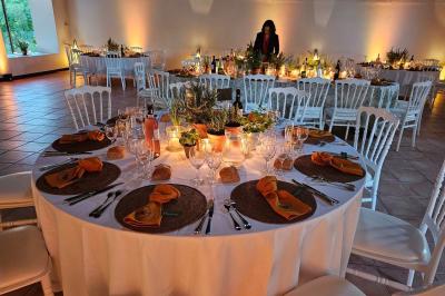 Salle spacieuse avec carrelage au sol, grandes baies vitrées, poutres apparentes et lustres suspendus.