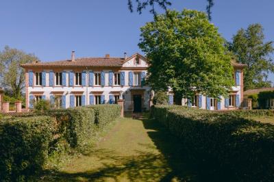 Salle spacieuse avec carrelage au sol, grandes baies vitrées, poutres apparentes et lustres suspendus.