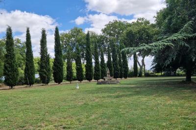 Salle spacieuse avec carrelage au sol, grandes baies vitrées, poutres apparentes et lustres suspendus.