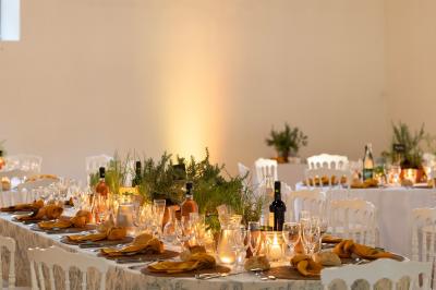 Salle spacieuse avec carrelage au sol, grandes baies vitrées, poutres apparentes et lustres suspendus.